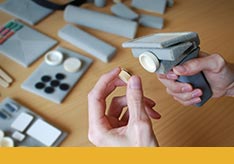 A thumbnail image of a person holding a low fidelity prototype of an object. Materials that made the object are shown in the background.