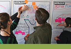 A thumbnail image of three people at a whiteboard and two people are adding voting tabs to the whiteboard